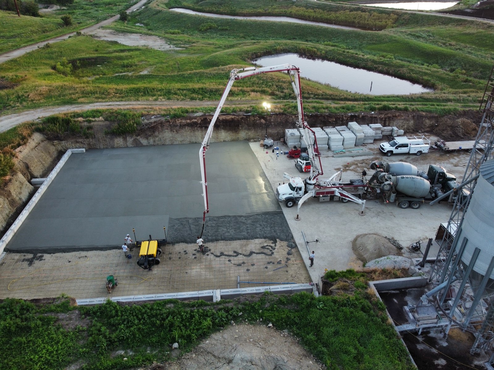 Concrete pump and ready-mix truck placing a large screeded floor